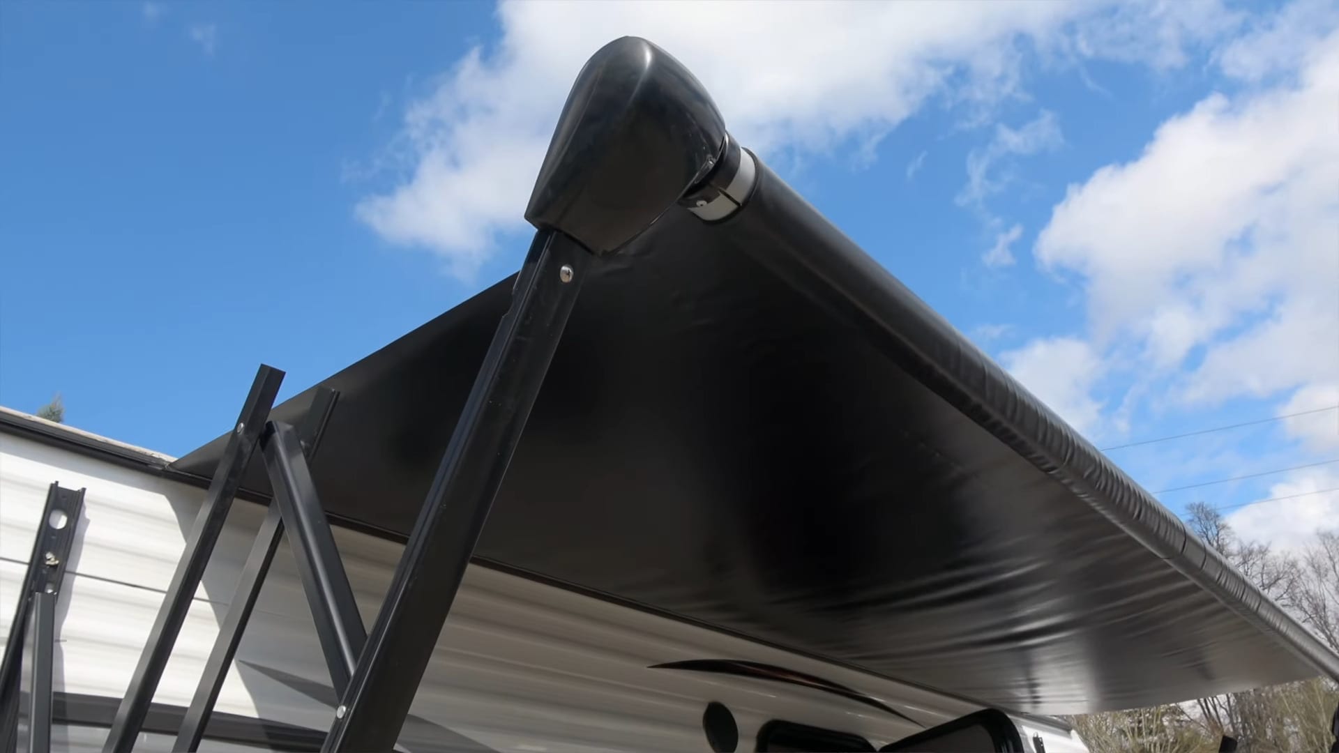 The arms of an RV awning are strong and can damage your RV if they break in the win.