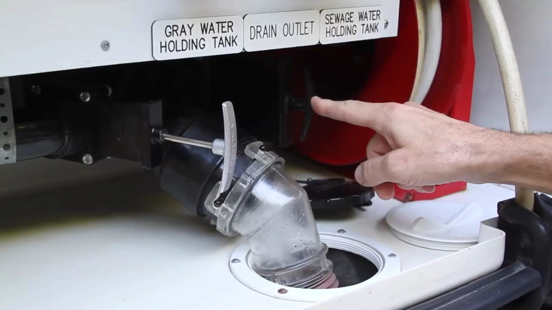 RV newbie mistakes to avoid shows a photo of The RVgeeks gray tank open and ready to drain.