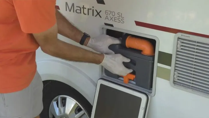 Removing the waste tank portion of a built-in cassette toilet from a door on the side of an RV