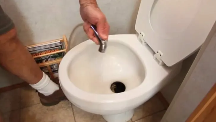 Cleaning toilet bowl with water sprayer