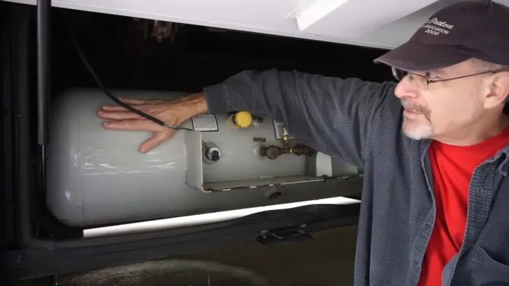 Using a hand on the side of the tank to detect warmth or cold to figure out the level of propane in the tank.