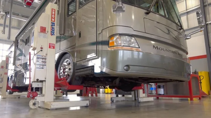 A motorhome on lifts at an RV mechanic service station