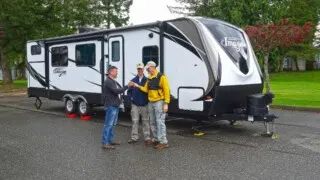 Photo of The RVgeeks leveling a travel trailer with a friend.