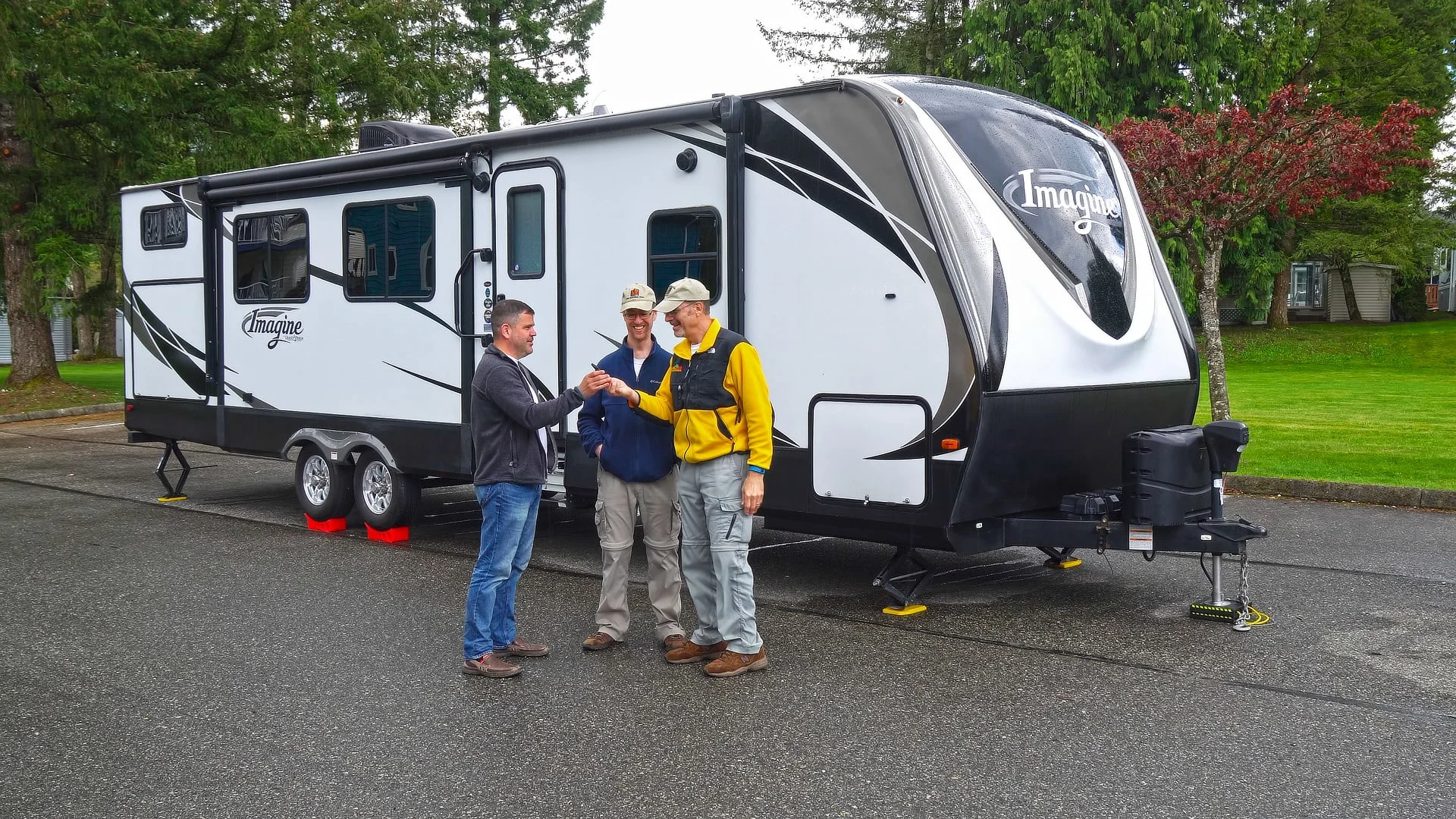 RV living tips are shown in this photo of The RVgeeks leveling a travel trailer with a friend.