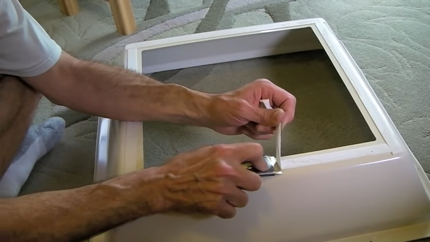 removing old tape during RV skylight inner dome replacement