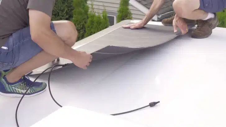 Flexible solar panel being positioned on roof.