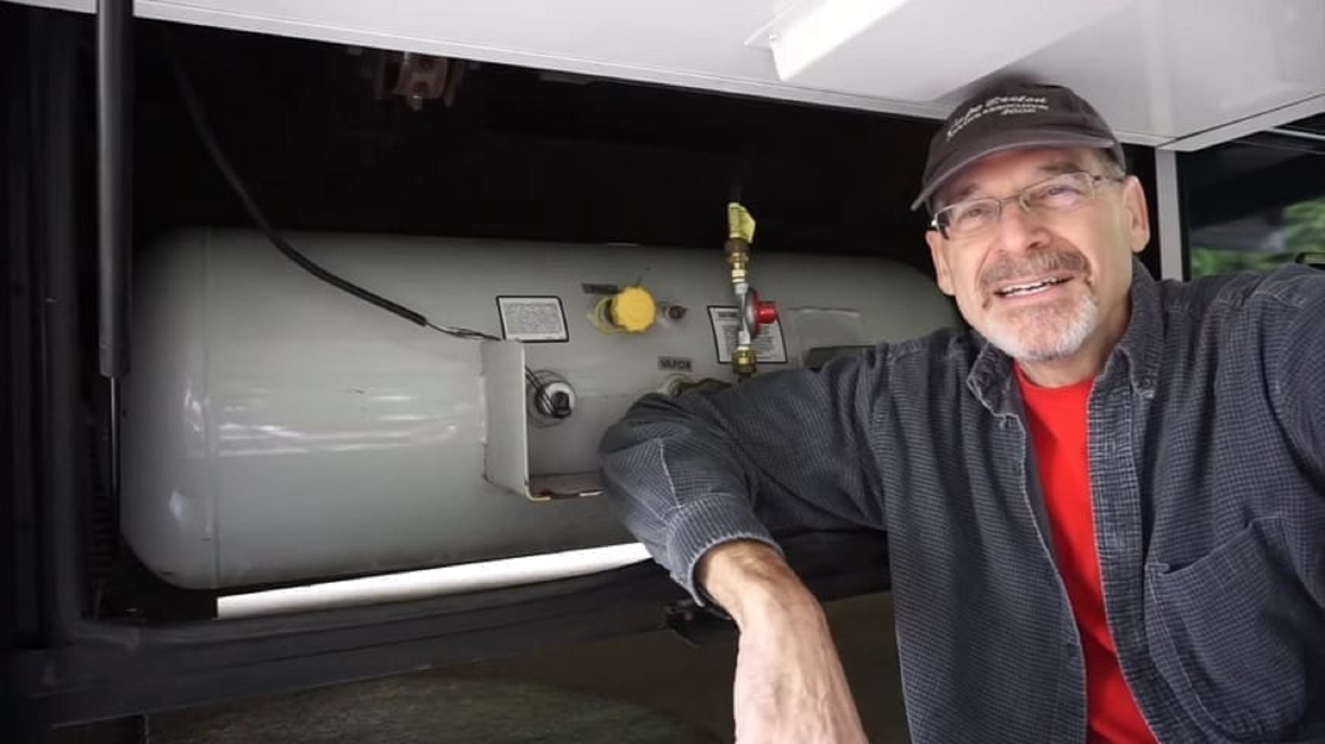 Photo of Peter beside the propane tank on board The RVgeeks' motorhome - one of our full-time RV living expenses