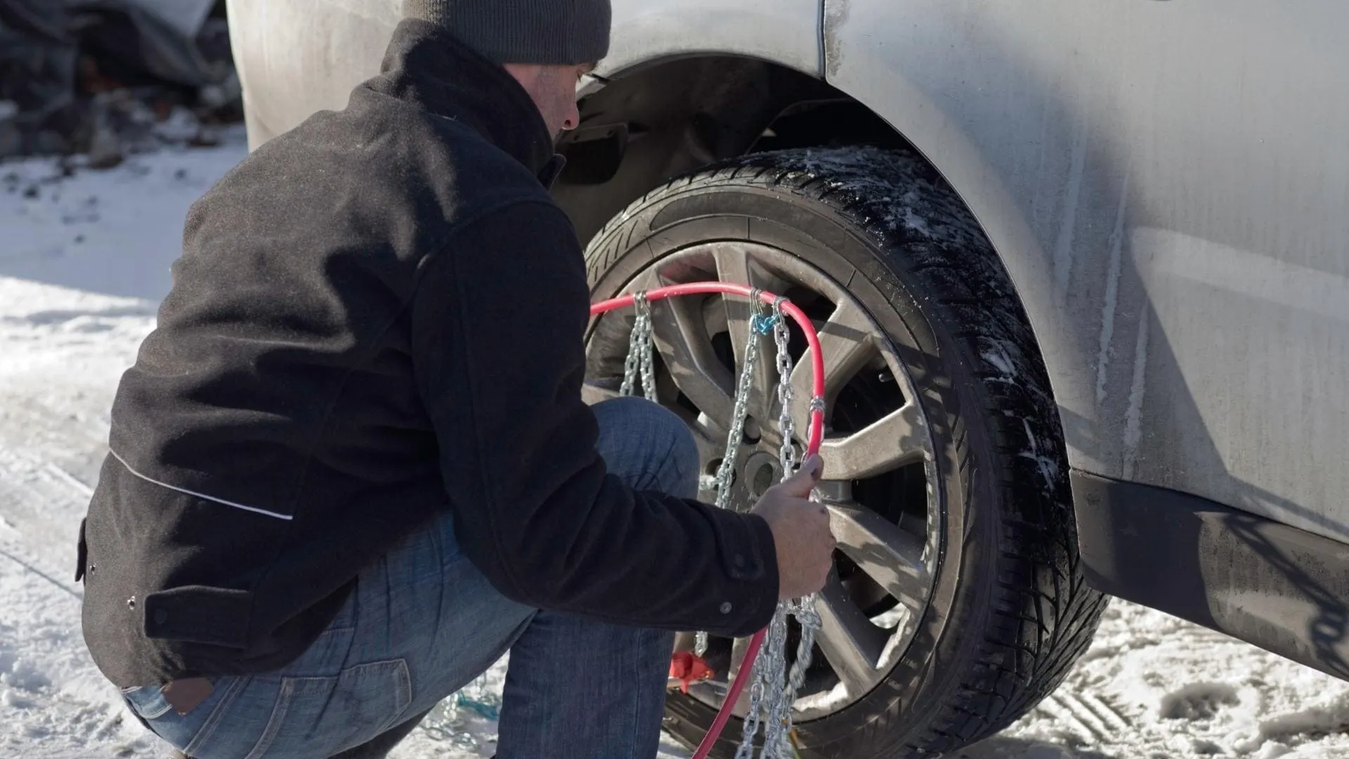 A man installing snow chains