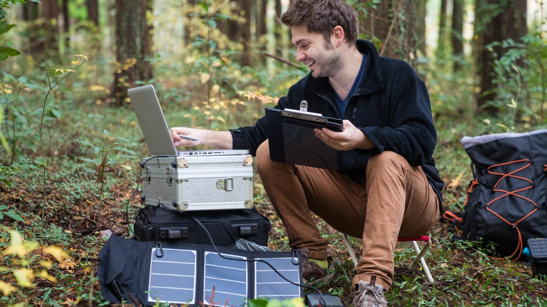 Man camping with solar powered portable power station.