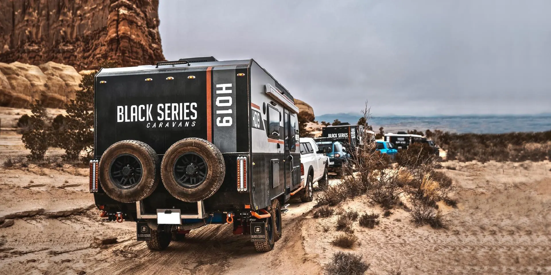 Photo of three Black Series campers traveling through a mix of tough terrain