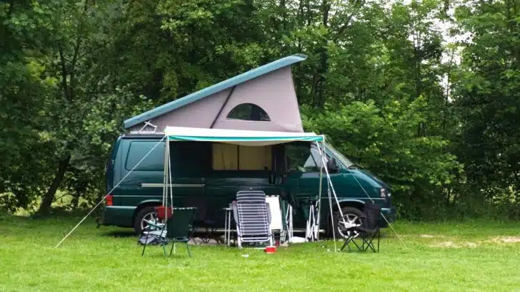 Photo of a camper van parked among the trees