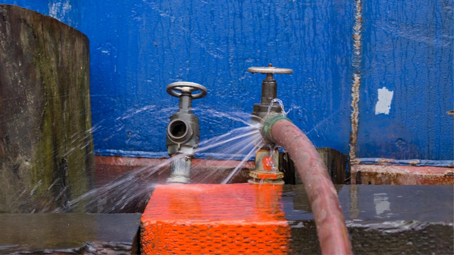 Photo of an ill-fitting hose spraying water