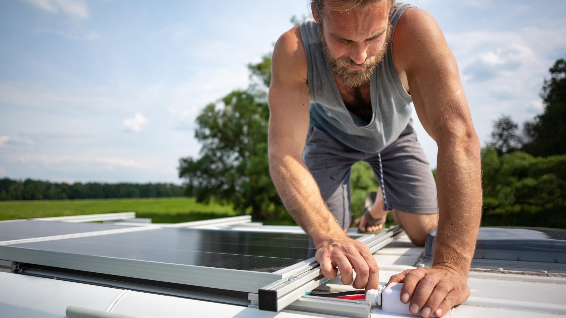 Photo of a man connecting solar panels to a rooftop port of solar ready RV