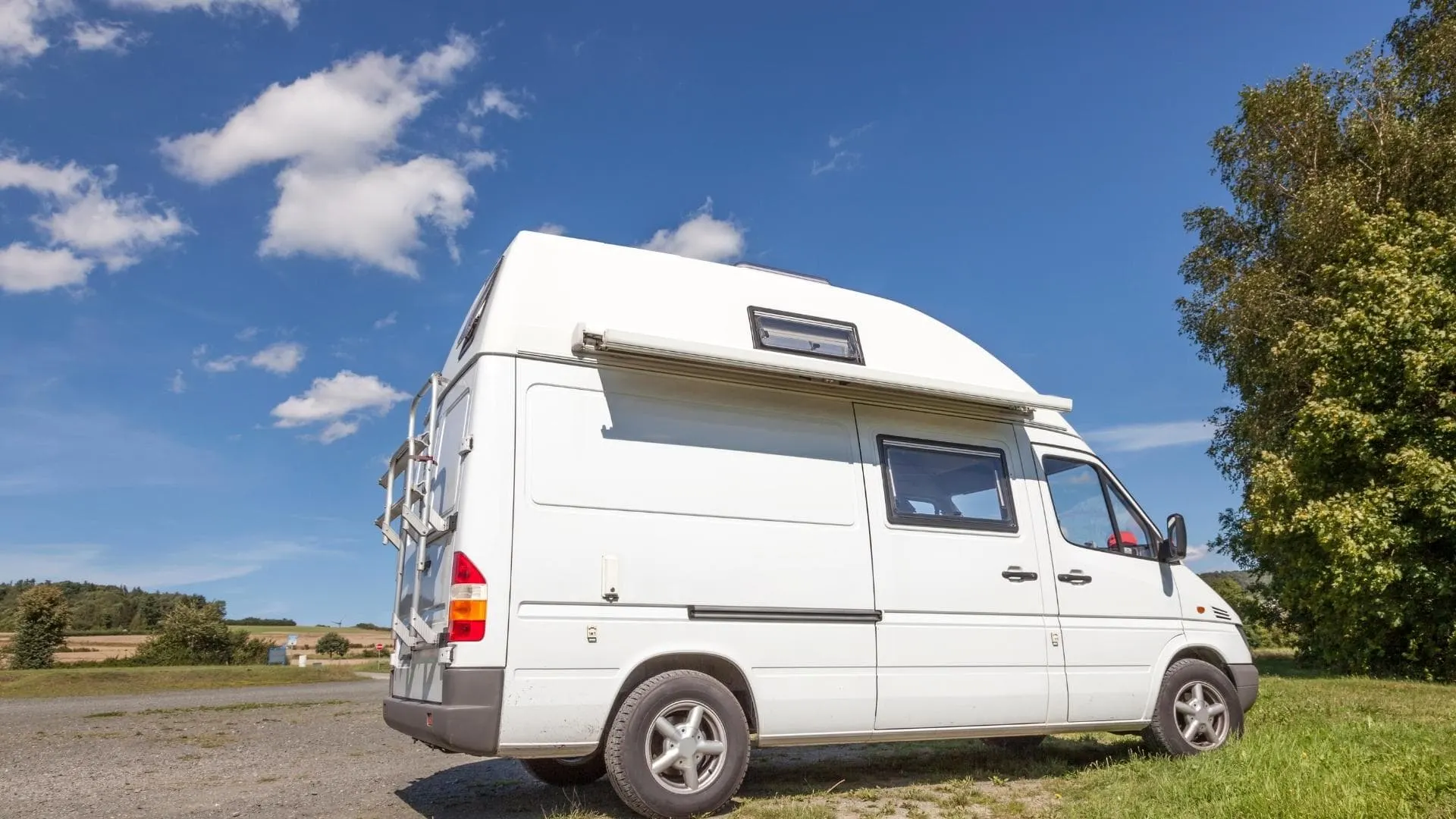 Photo of a small camper van parked in a small space roadside, one of the benefits of smaller RVs