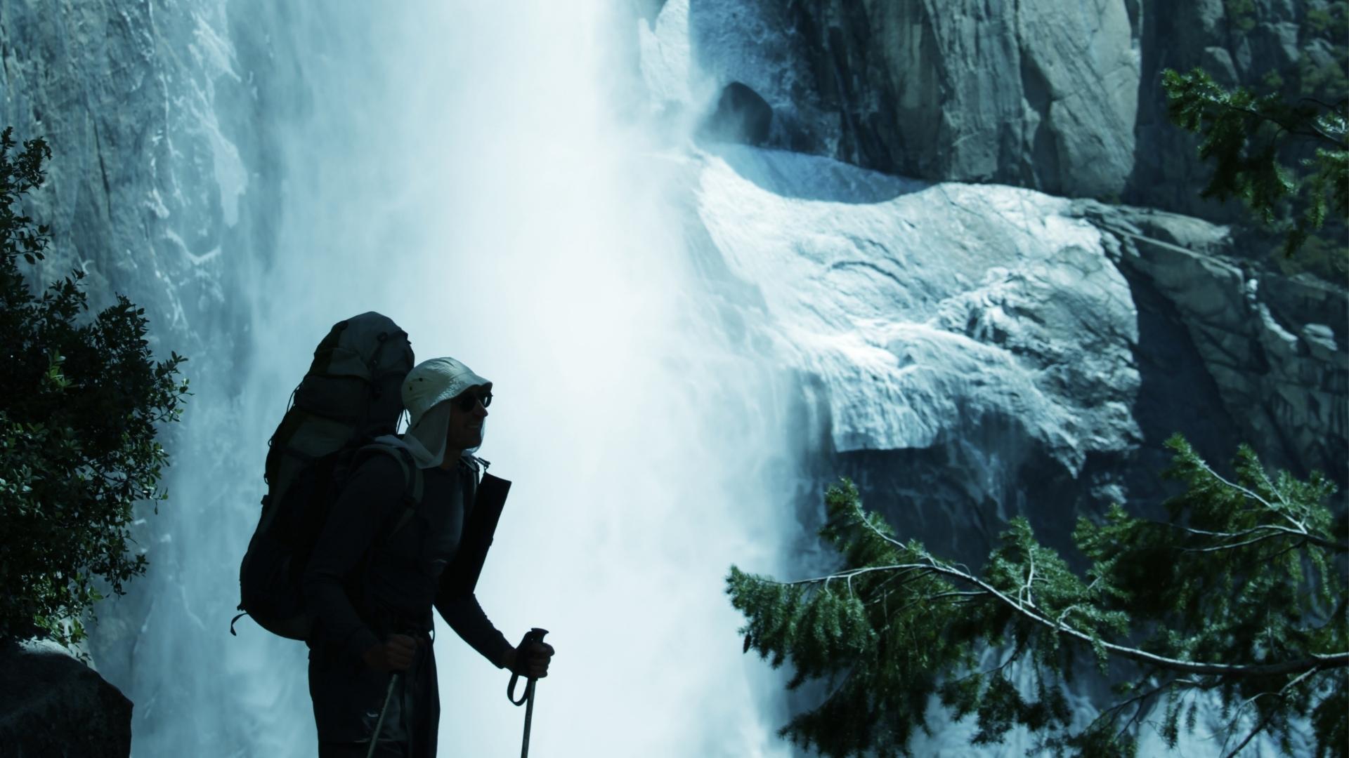 Photo of a hiker near a waterfall in Yosemite National Park
