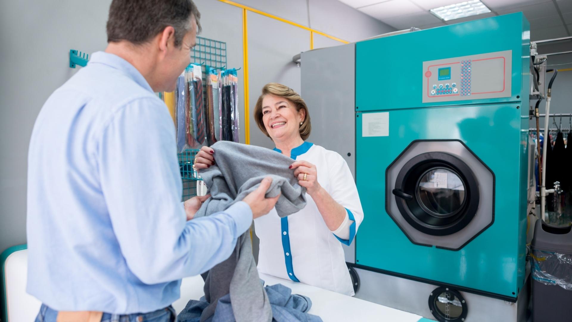 A man talking with an attendant at a laundry service