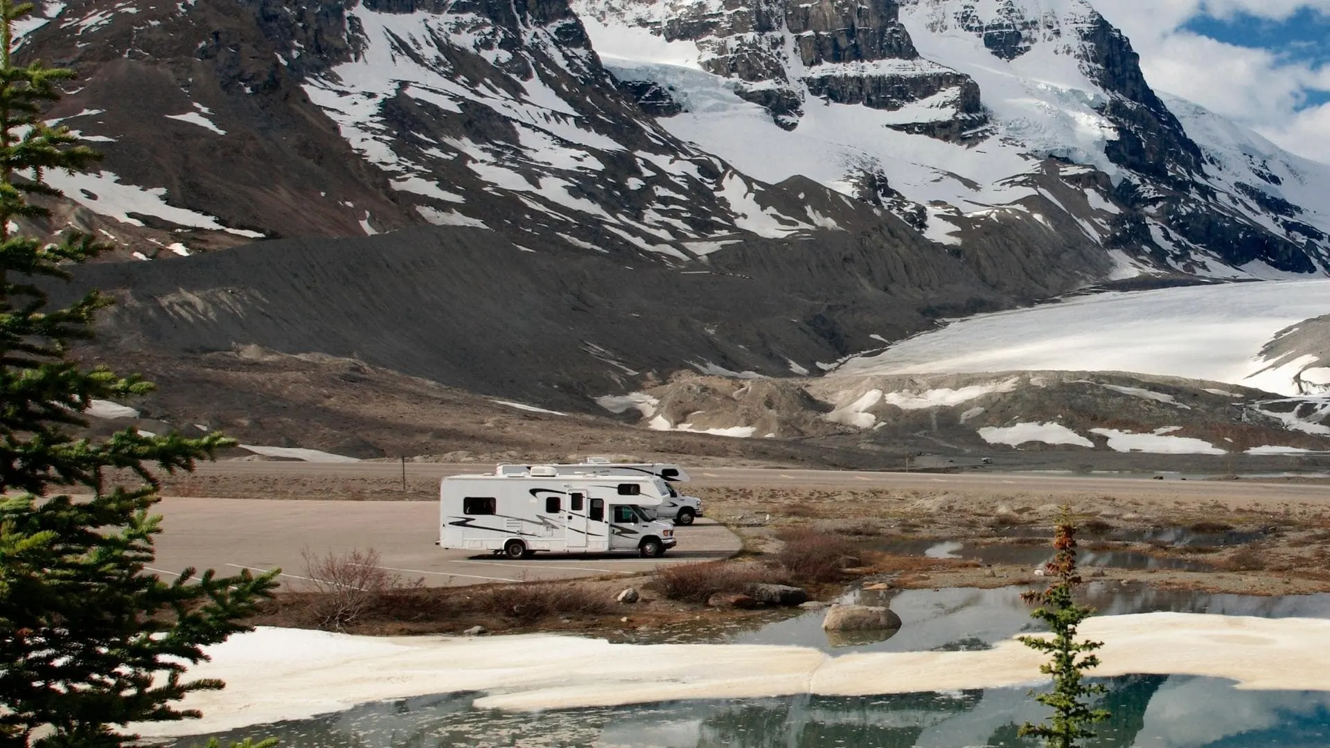 Photo of RVs boondocking on land below snow-covered mountains