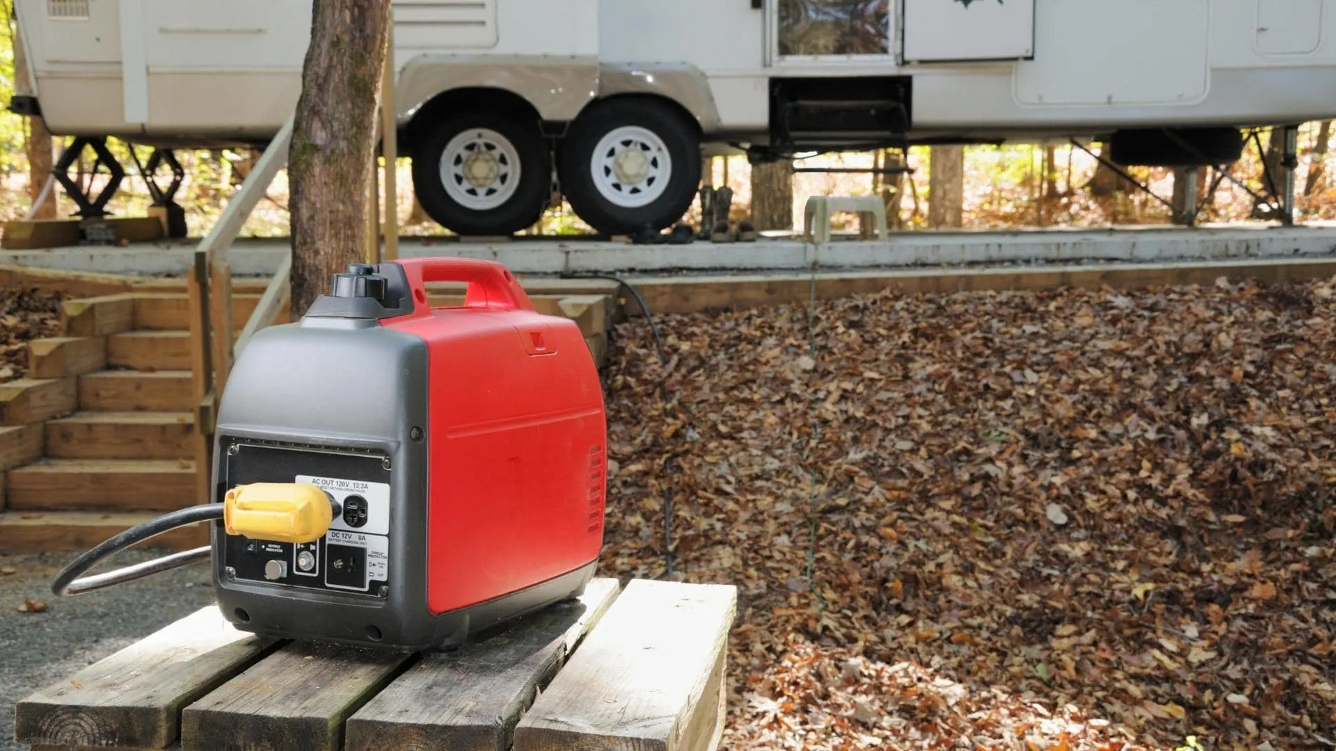 Photo of a small inverter generator sitting on a picnic table a fair distance away from the RV to which it delivers power