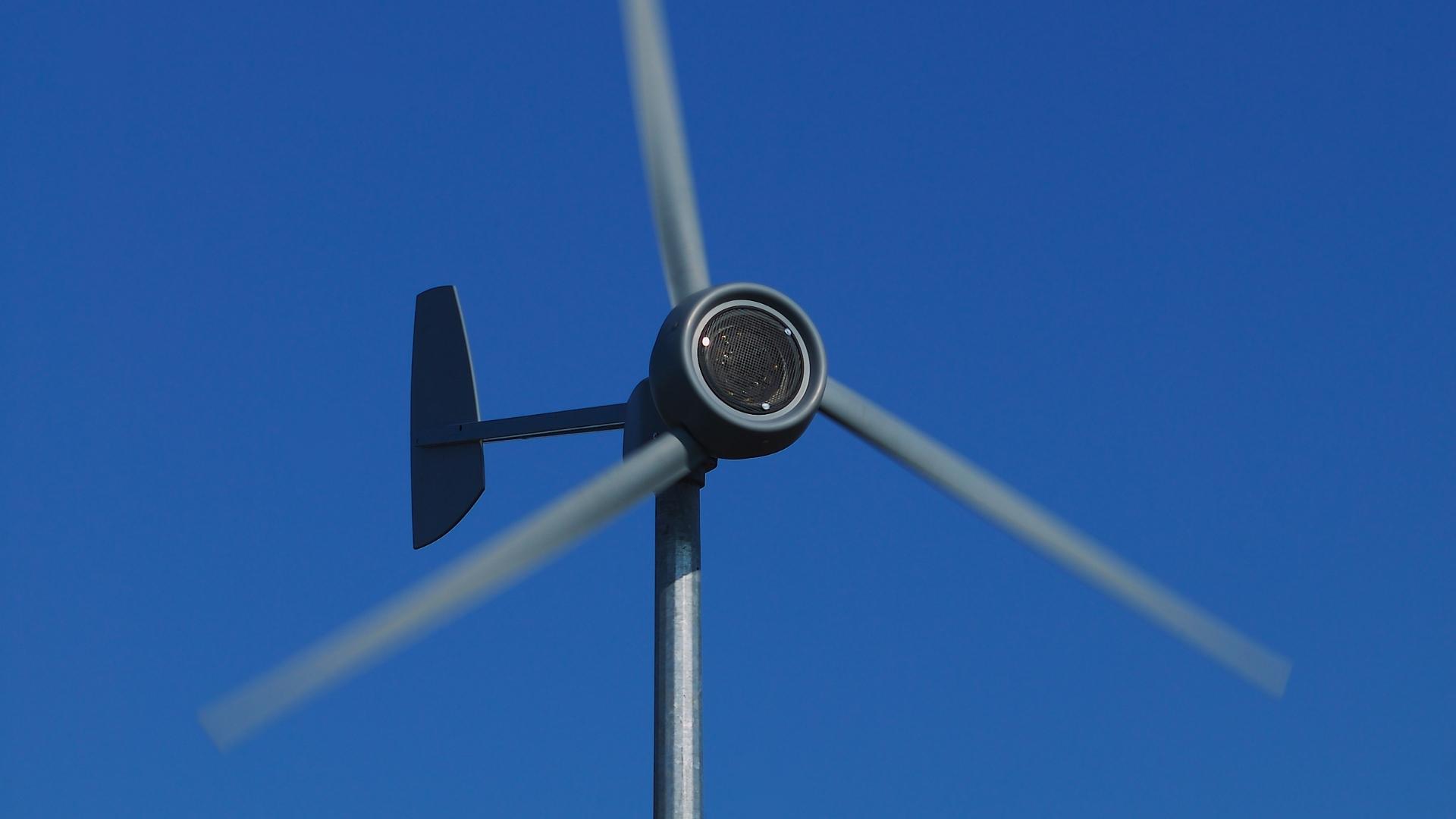 Photo of the blades of a wind turbine spinning in windy conditions