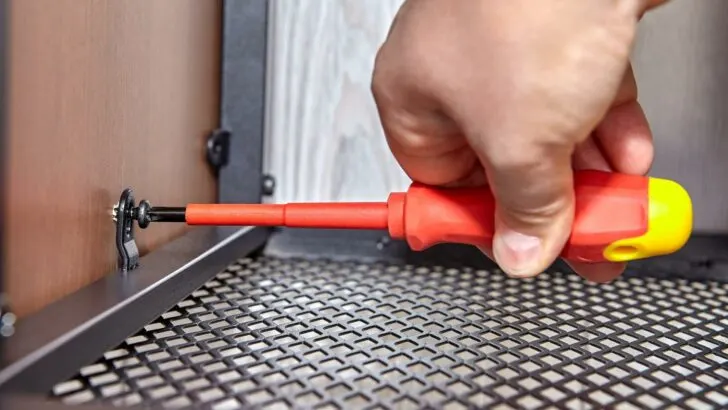 Using a screwdriver to tighten a screw and prevent RV rattles