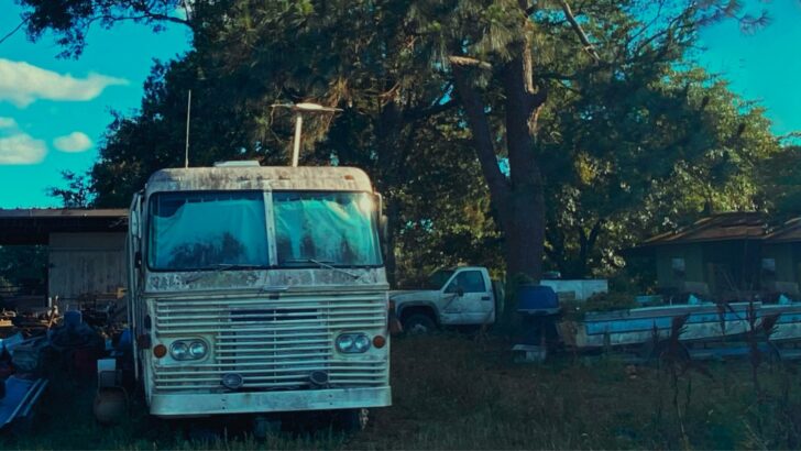 An old, poorly maintained motorhome parked on a property