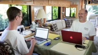 The RVgeeks working on computers at a desk in their RV