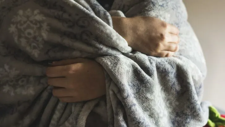 A person wrapped in a heated blanket