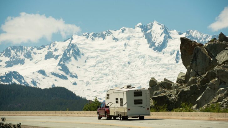 An RV with snow-covered mountains in the background