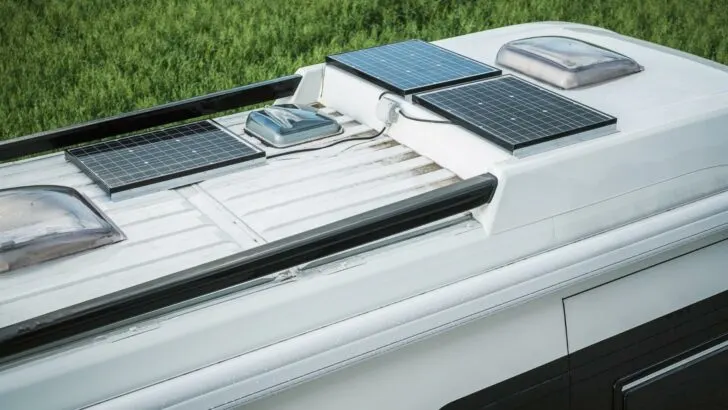Three solar panels mounted on the roof of an RV