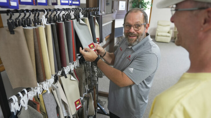 Bradd & Hall's owner, Bradd Neidhamer, shows John a variety of fabric options.