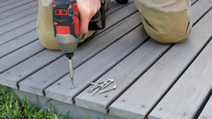A person using a drill to put together a deck