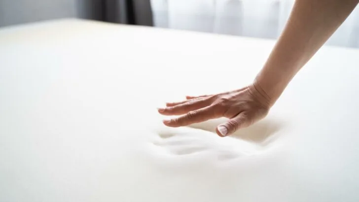 A memory foam mattress showing a hand print to illustrate the conforming nature of the material