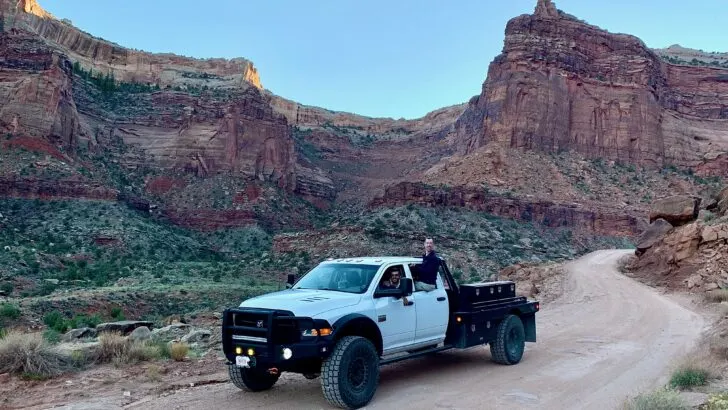 A large truck with super single tires and canyons in the background