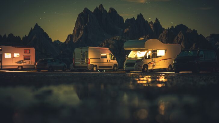 RVs parked by a pond at night