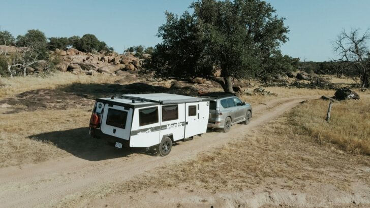 The TAXA Mantis 4.1 being towed along a dirt road by an SUV