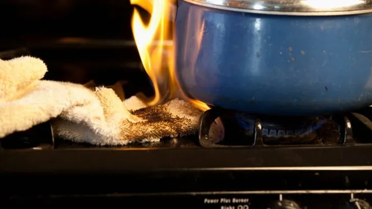 A hand towel near the open flame of a propane stove catching fire