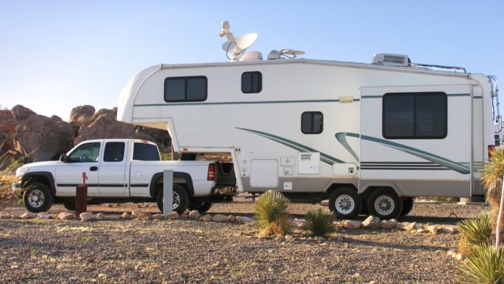 A smaller fifth wheel hitched to a pickup truck