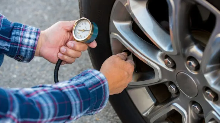 A person checking tire pressures