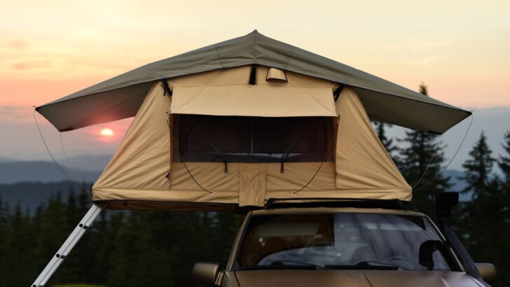 A rooftop tent shown erected on the roof of a truck.