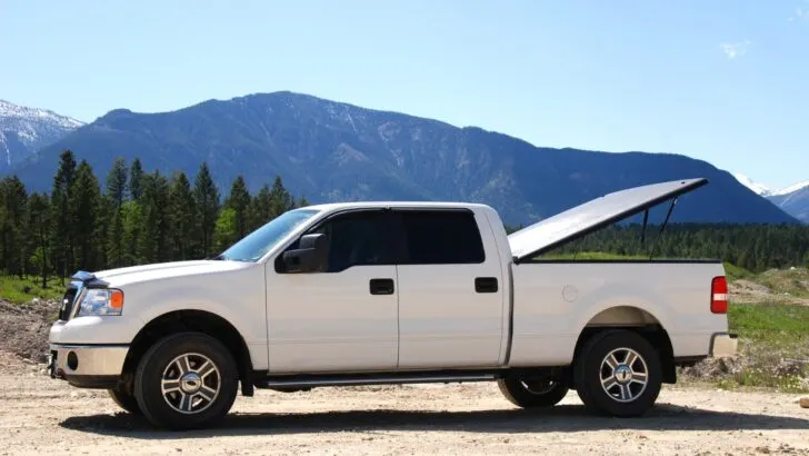 Pickup truck with a flat, rigid bed cover attached