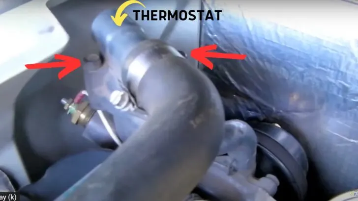 Location of the thermostat and the two bolts that need to be removed identified