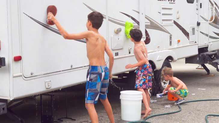 Kids participating in the washing of a large travel trailer
