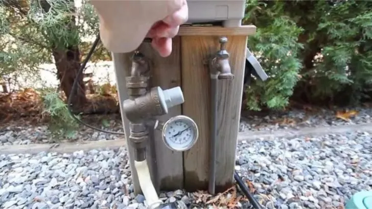 A water pressure regulator and hose connected to a city water source at a campground