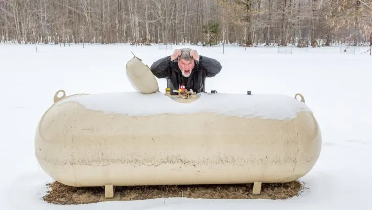 Propane tank in the snow with frustrated man