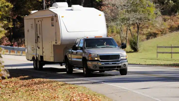 A pickup truck towing a fifth wheel camper