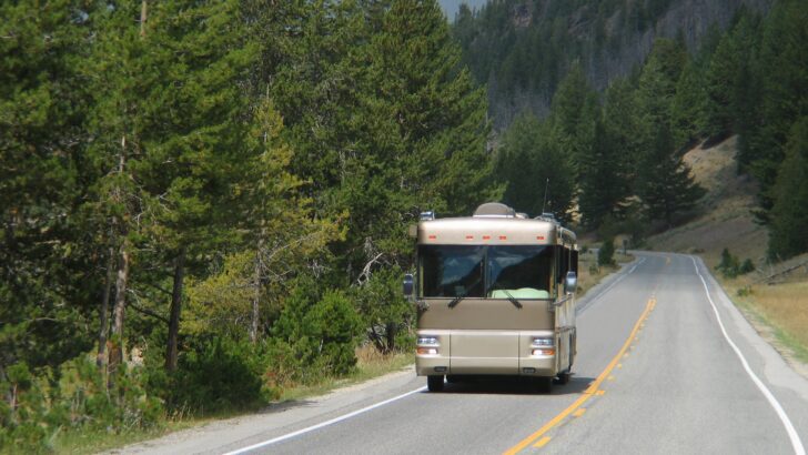A Class A motorhome traveling down a straight stretch of road