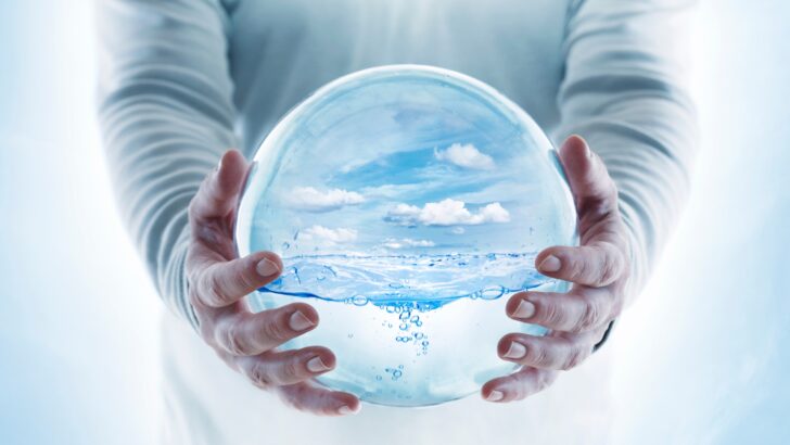 A globe containing a finite amount of water, held by two hands