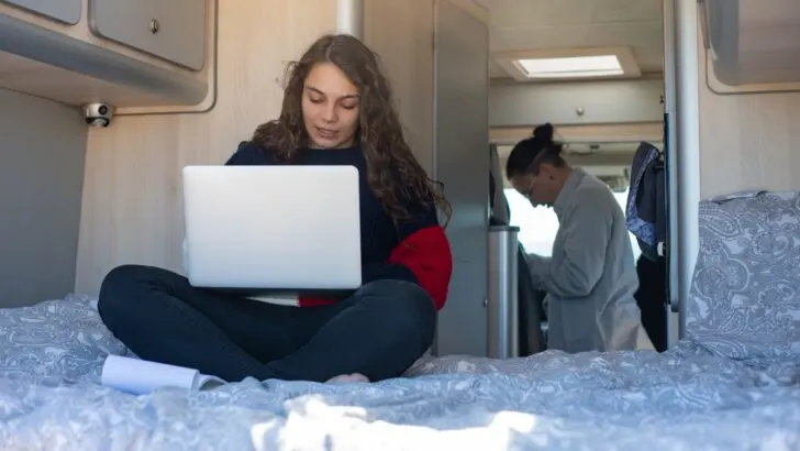 A young teen working on a computer in an RV - debunking full time RV myths.