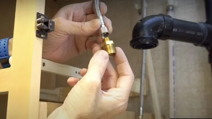 A brass adapter being connected to the new fitting