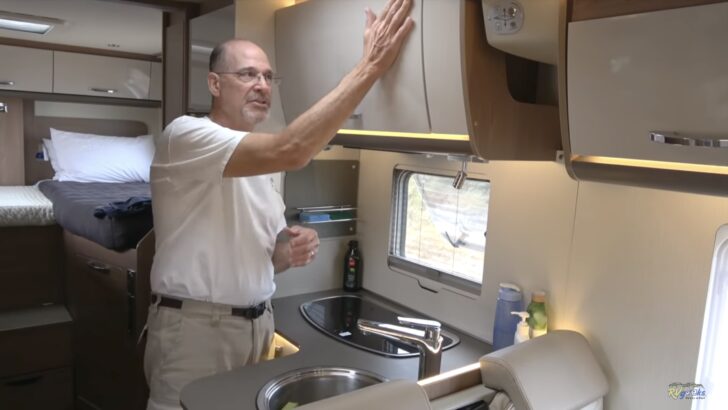 Peter showing the cabinets of the Class B RV we rented to travel around New Zealand